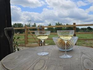 two glasses of white wine sitting on a table at The Barn at Whistley Fields in Devizes