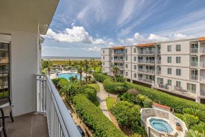 un balcon d'appartement avec vue sur la piscine et l'océan dans l'établissement Beach Club #313, à Île de Saint-Simon