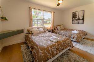 オーランドにあるSpacious Modern Japandi Retreat - Winter Parkのベッド2台と窓のある寝室