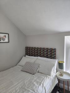 a white bed with a pillow on it in a bedroom at Galway City - 135 Bohermore in Galway