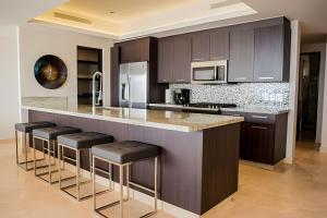 卡波圣卢卡斯Cascadas del Pedregal的一个带酒吧凳的大岛的厨房