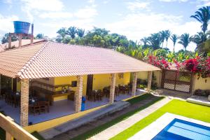 a villa with a dining area and a swimming pool at Pousada Sítio Machado in Viçosa do Ceará