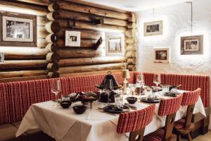 a dining room with a table with plates and wine glasses at Hotel Römerhof Superior in Obertauern