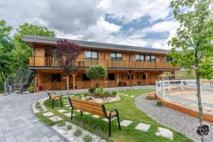 a building with two benches in front of it at Ecvestria Chalet in Ocnele Mari