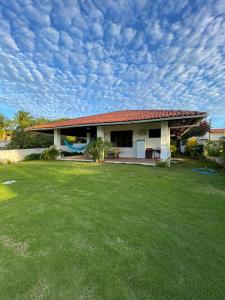 a house with a green lawn in front of it at Casa Vila lagoinha in Lagoinha