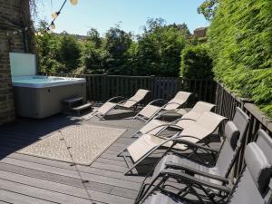 a group of chairs sitting on a deck with a tub at The Old Post Office - Pet Friendly Group Stays in Holmfirth in Holmfirth