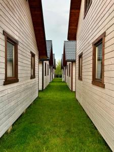 a row of buildings with grass between them at Domki letniskowe MagNat 700m od morza! in Rusinowo