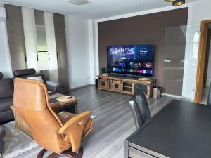 a living room with a tv and a table and chairs at Appartment 34 Lüdenscheid Hellersen Süd in Lüdenscheid