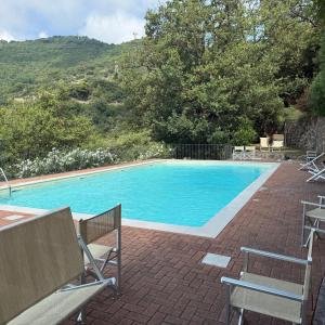 a large swimming pool with chairs and a table at Domus Luxury villa Alassio in Alassio