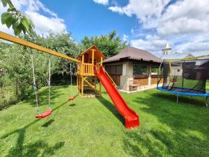 a playground with a slide and swings in a yard at Casa Sofia in Vama