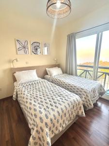 two beds in a room with a window at STAY Pantheon Villa in Pissouri