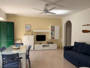a living room with a table and a blue couch at Il Piccolo Giardino in Levanto