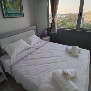 a bedroom with a white bed with towels on it at Nancy view apartment in Markopoulo