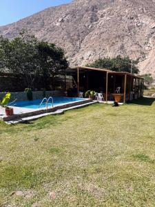 une maison avec une piscine et une montagne en arrière-plan dans l'établissement Casa de Campo La Chocita de Gladis, à Santa Rosa de Quives