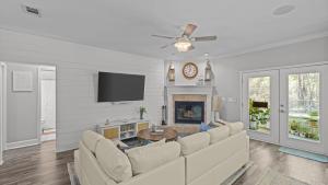 a living room with a white couch and a fireplace at FREE GolfCart, Firepit, Bikes, Paddleboards, Beach, Private in Inlet Beach