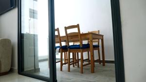 a dining room table with two chairs and a mirror at Apartment - Mehdia Beach in Kenitra