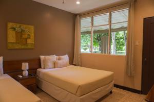 a bedroom with two beds and a window at Hotel Diriá Santa Cruz in Santa Cruz
