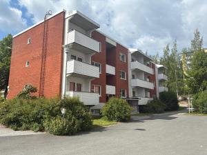 a red brick building with balconies on the side of it at Modern studio, good location, free parking in Kuopio
