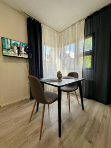 クオピオにあるModern studio, good location, free parkingのテーブルと椅子と窓のあるダイニングルーム +1枚の写真