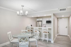 a kitchen and dining room with a table and chairs at Sundial F106 - Renovated Ground Floor Residence at Sundial Sanibel in Sanibel