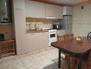 a kitchen with a wooden table and a counter top at Aires de Mendoza in Maipú