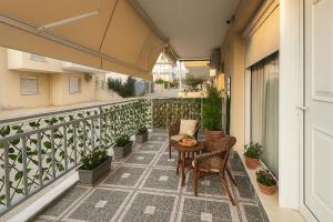 a balcony with a table and chairs and plants at Studio Lumo in Nea Moudania