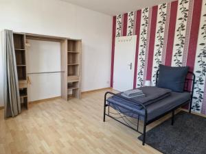 Zimmer - Alte Weinkellerei في Stadtilm: غرفة معيشة فيها كرسي وثلاجة