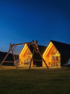 a swing set in front of a log cabin at Eternum Glamping in Žabljak