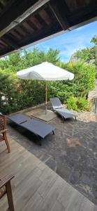 a patio with two benches and an umbrella at Villa Margherita in Maratea