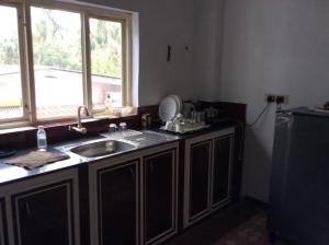 a kitchen with a sink and a window at Redrose Service Apartment in Kannur