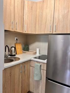 a kitchen with wooden cabinets and a stainless steel refrigerator at Przytulnie nad zatoką in Jastarnia