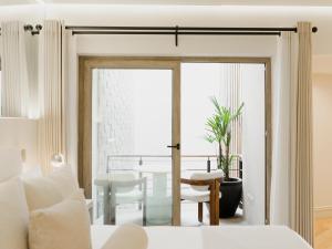 a bedroom with a door leading to a dining room at Hotel Maria Camille in San Miguel de Allende