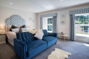 a bedroom with a blue couch and a bed at Cilrhiw Country House - Princes Gate in Narberth
