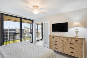 a bedroom with a bed and a flat screen tv at Sundial F406- Stunning Fully Equipped Residence at Sundial Sanibel in Sanibel +8 photos
