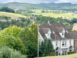 a group of houses on a hill with trees at Harefield in Morpeth