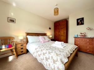 a bedroom with a bed and a wooden dresser at Harefield in Morpeth