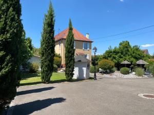 a house with trees in front of a driveway at Les Rives des Habsbourg in Ensisheim