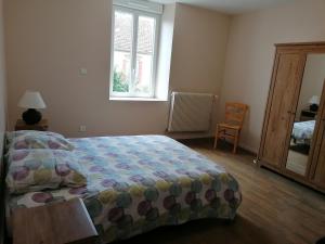 VaillantにあるMaison de village tout confortのベッドと椅子と窓のある寝室