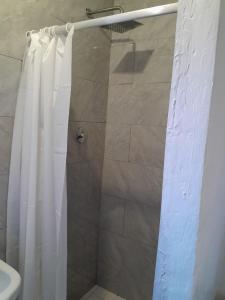Una ducha con una cortina de ducha blanca en un baño. en Russell's Rest Apartments, en Johannesburgo 7 fotos más