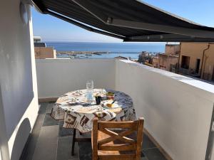 a table on a balcony with a view of the ocean at Fantastic sea & harbour view Nino Bixio in Castellammare del Golfo