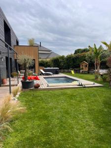 un cortile con piscina e prato verde di Contemporary architect's house, pool, jacuzzi a Deauville