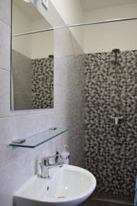 a bathroom with a sink and a mirror and a shower at Ház a tónál Noszvaj in Noszvaj +5 photos