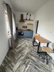 a kitchen with a table and a wooden floor at Airport Green 2 in Cluj-Napoca +7 photos