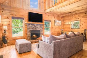 Una sala de estar con un sofá y una chimenea. en River Fishing Cabin, en Lakemont