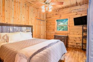 Un dormitorio con una cama y un ventilador de techo. en River Fishing Cabin, en Lakemont
