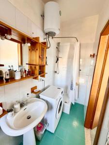 a bathroom with a sink and a washing machine at Fantastic sea & harbour view Nino Bixio in Castellammare del Golfo +50 photos