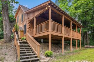 una gran casa de madera con escaleras que conducen a ella en River Fishing Cabin, en Lakemont