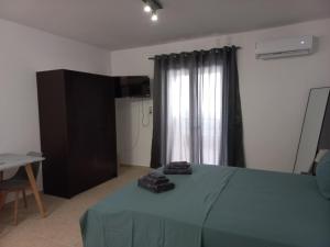 a bedroom with a green bed and a window at Sophie's Sunny Spot 5 in Yéfira