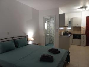 a bedroom with a green bed with two towels on it at Sophie's Sunny Spot 5 in Yéfira