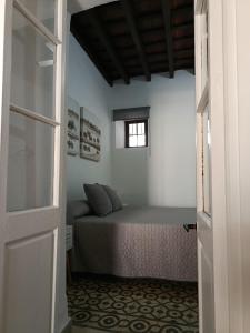 une chambre avec un lit et une fenêtre dans l'établissement Apartamentos Casa Vicario, à Jerez de la Frontera